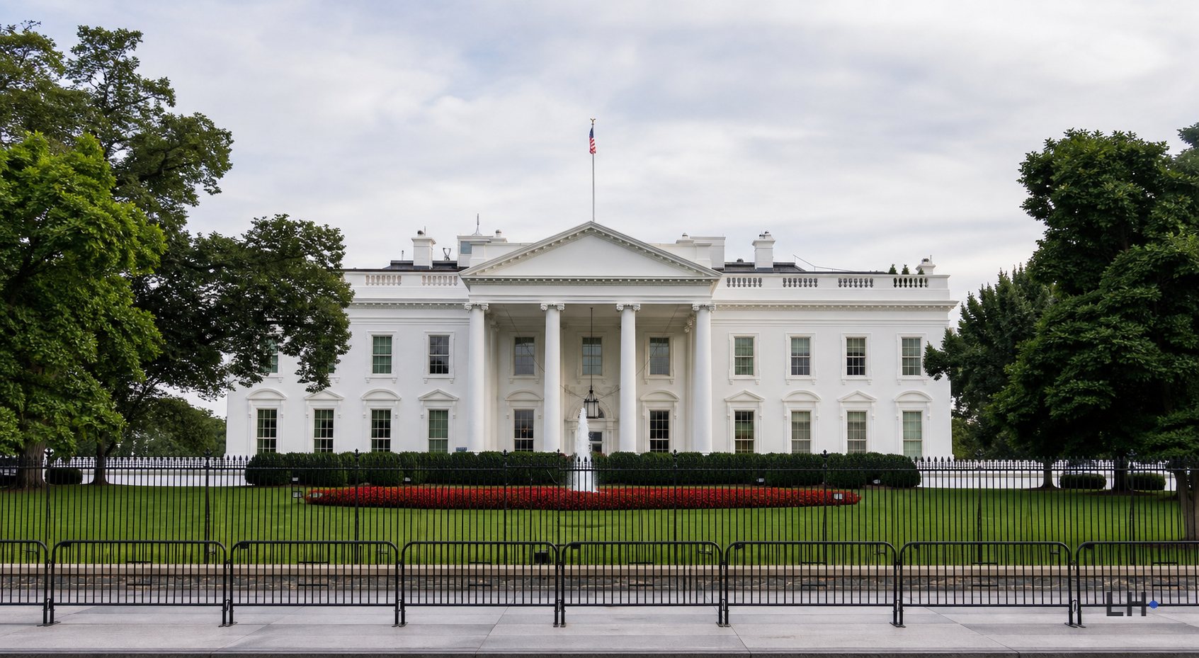 White House exterior behind a lawn and fence.